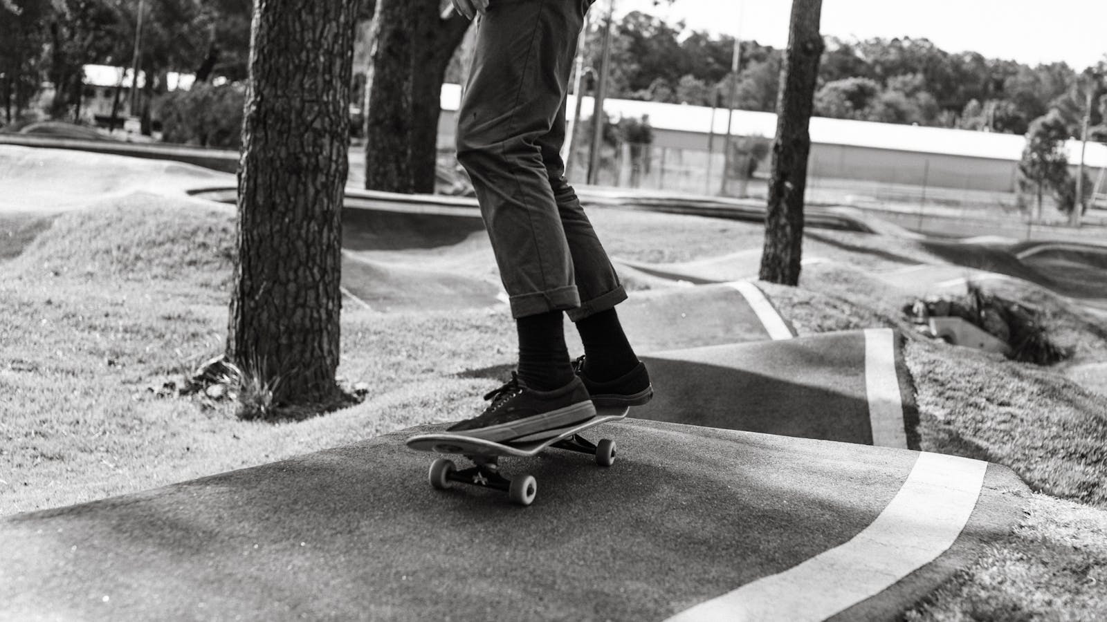 Skater riding a longboard on an asphalt ramp in golden light