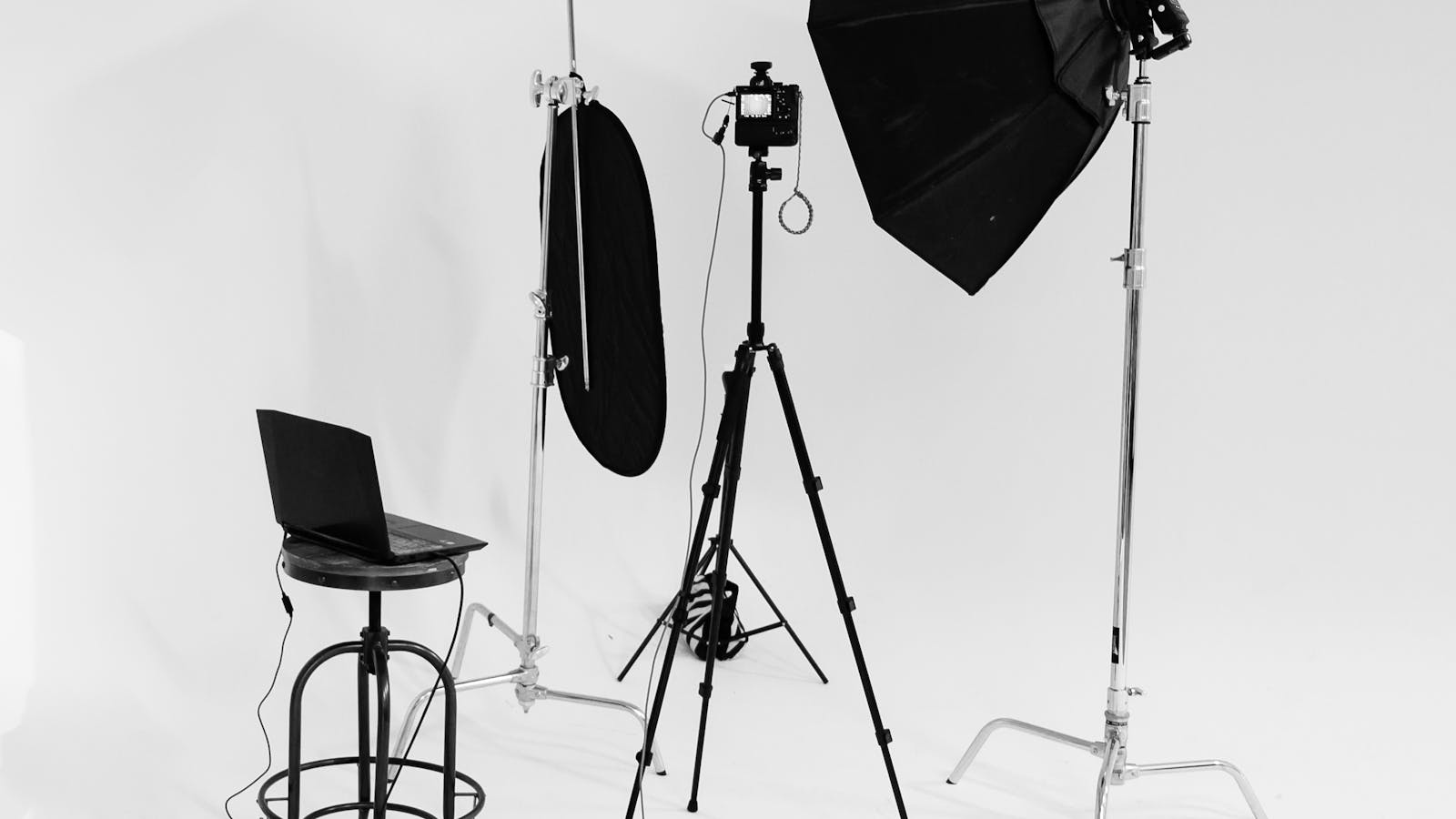 Black and white photography studio with lighting gear and seamless backdrop