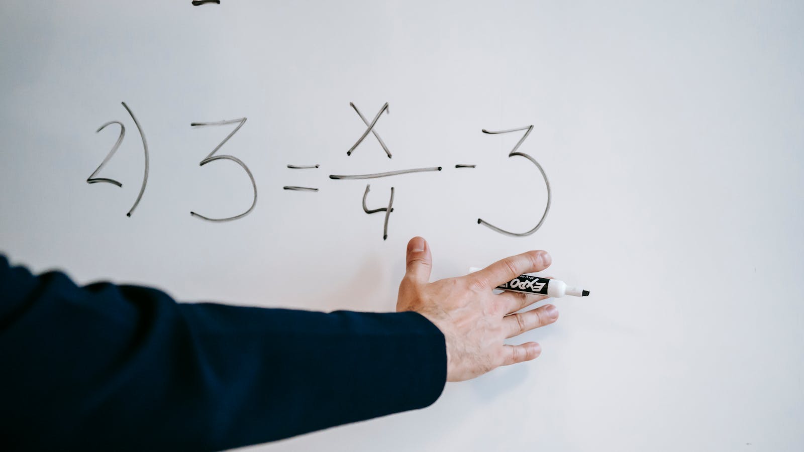 Instructor writing an equation on a whiteboard during a coding dojo