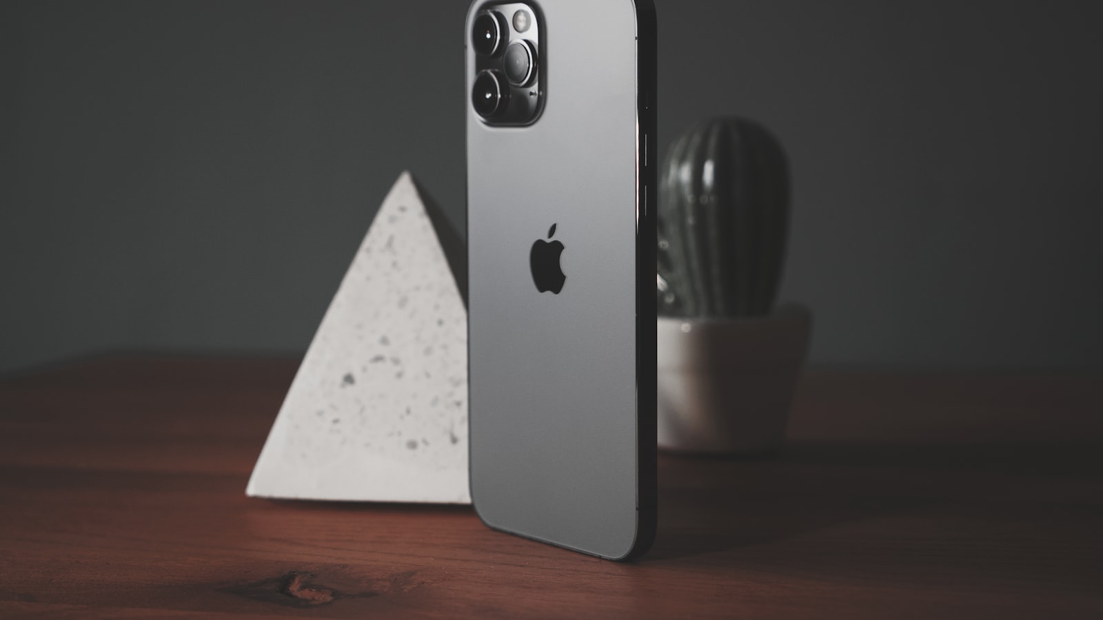 A silver iPhone resting on a silver MacBook, hinting at the wireless tether between phone and laptop