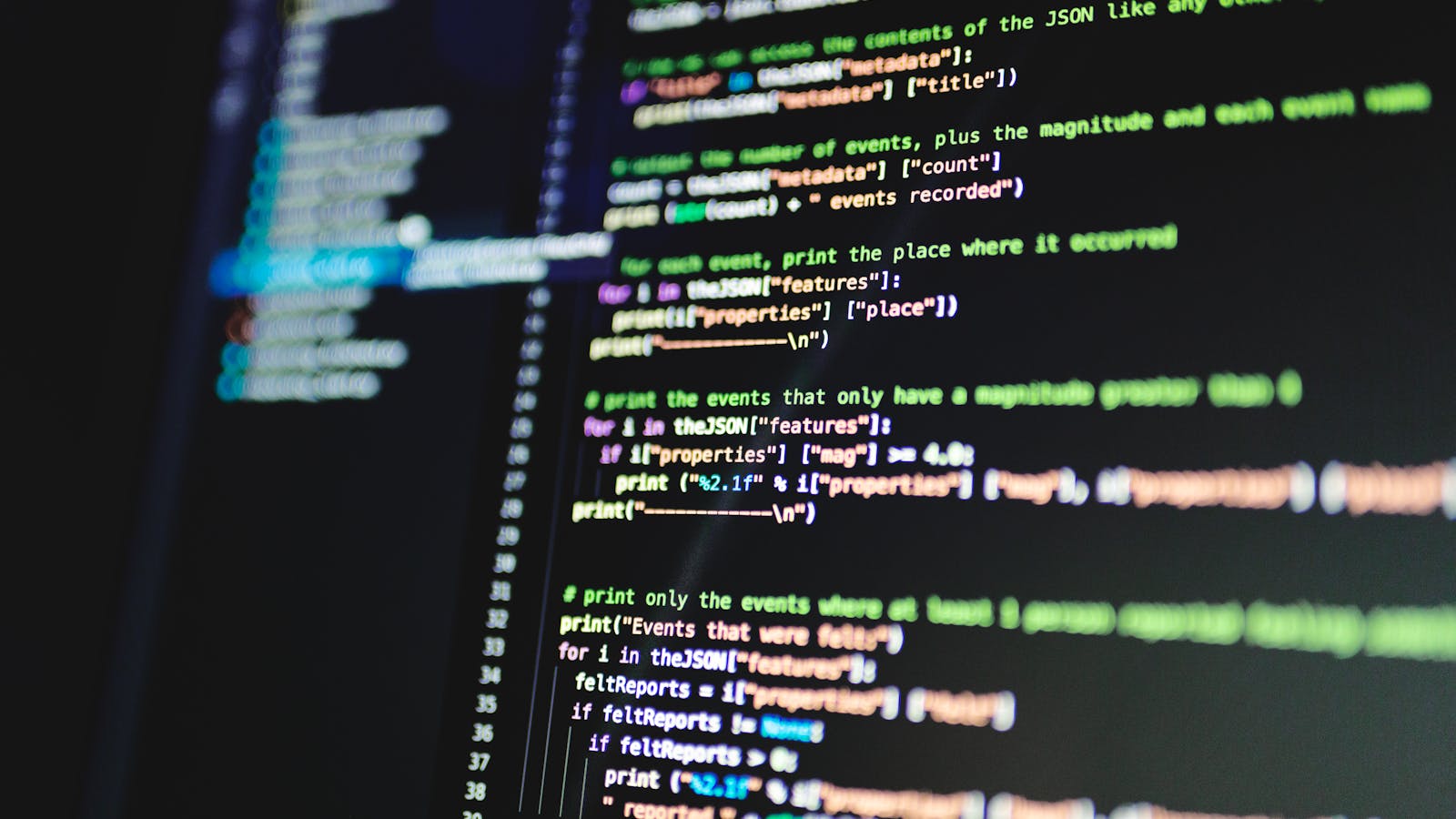 Monitor displaying bright programming code on a dark desk