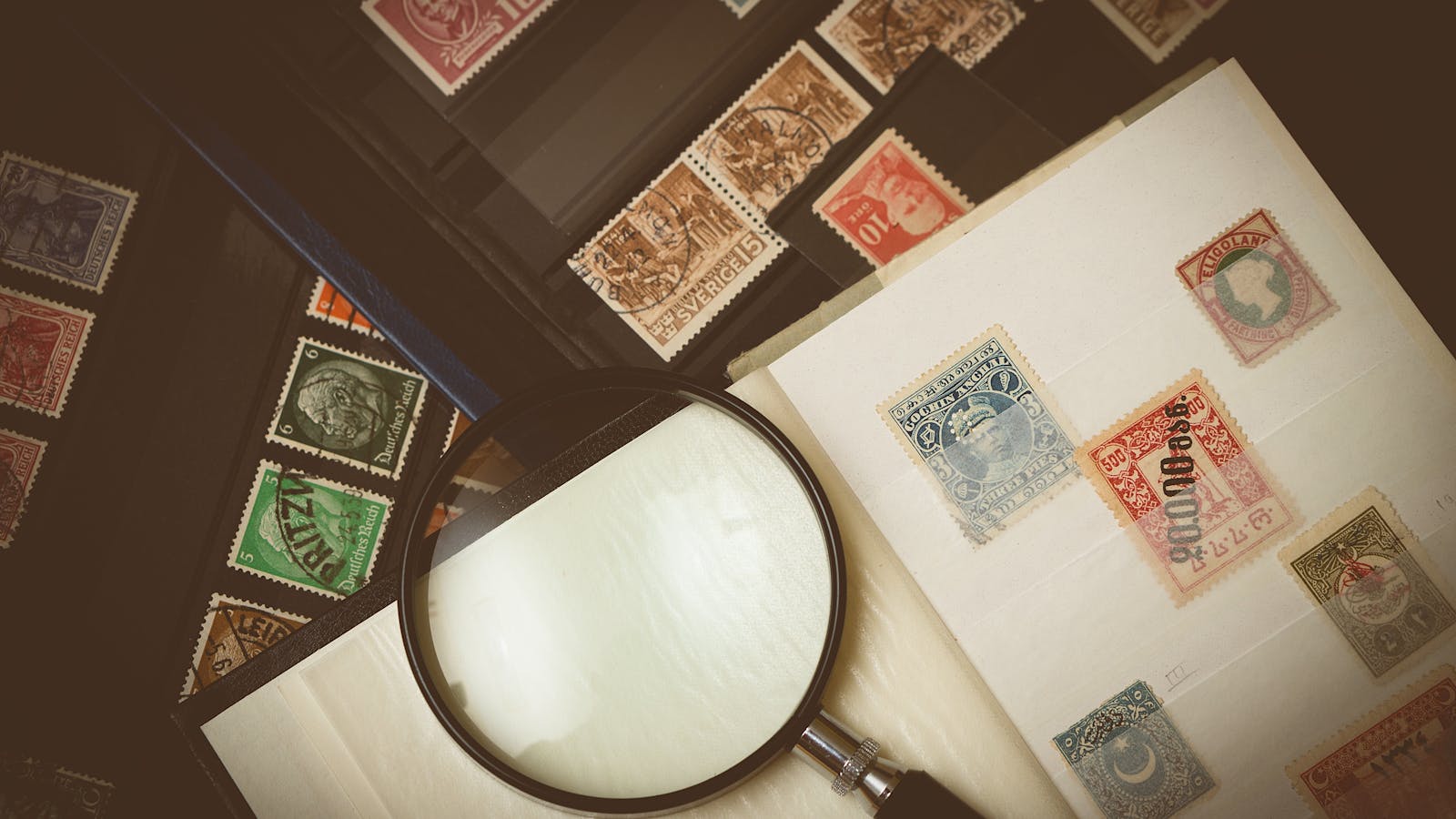 Close-up of a vintage postage stamp collection through a magnifying glass